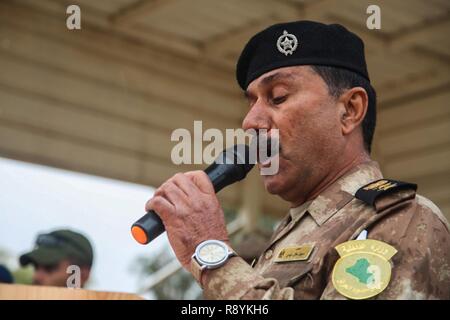 Un iracheno le forze di sicurezza officer letture del Corano durante una cerimonia di laurea a gamma Besemaya complessa, Iraq, 16 marzo 2017. Besmaya è uno dei quattro Combined Joint Task Force - Funzionamento inerenti risolvere la costruzione di capacità del partner location dedicate alla costruzione di capacità del partner. CJTF-funzione OIR è il global Coalilition per sconfiggere ISIS in Iraq e la Siria. Foto Stock