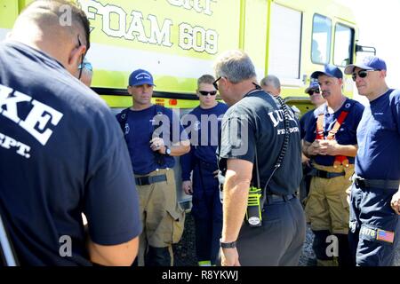 Steven Kinkade, 56th ingegnere civile Squadron assistente capo fuoco, parla con Scottsdale vigili del fuoco dopo aver completato un corso di formazione per esercizio Mar. 16, 2017 a Luke Air Force Base, Ariz. L'obiettivo dell'esercizio è stato per controllare i mezzi di uscita e di evacuazione delle vittime mentre si stabilizza il fuoco. Foto Stock