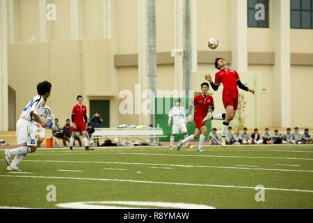 Un accademia canadese giocatore di calcio da Kobe testa-butts un pallone da calcio in una partita contro Noda Gakuen High School da Yamaguchi città durante il Perry Cup Soccer Tournament 2017 al Marine Corps Air Station Iwakuni, Giappone, Marzo 18, 2017. Noda Gakuen ha vinto la partita contro l'Accademia Canadese 4-3 e il primo posto nel gruppo marrone rossiccio. Foto Stock