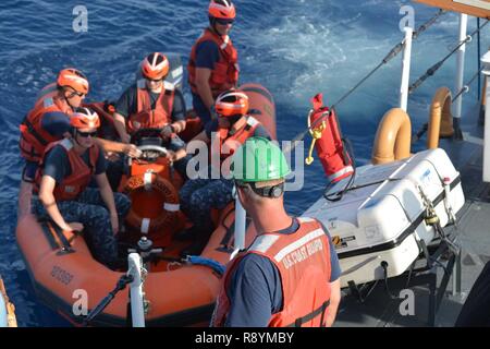 Un Coast Guard membro dell'equipaggio a bordo del guardacoste Galveston Island (WPB 1349) si prepara ad assistere U.S. Mare navale Cadet Corps cadetti sbarcare una piccola barca dopo la conduzione di training disattivato di Honolulu, Marzo 11, 2017. Il USNSCC è una marina-organizzazione di base che serve per insegnare ai ragazzi circa marittima servizi militari, U.S. Naval Operations e la formazione, i servizi alla comunità la disciplina e il lavoro di squadra. Foto Stock