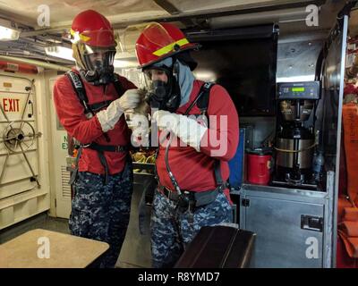 Stati Uniti Mare navale Cadet Corps cadetti preparare per condurre corsi di formazione antincendio a bordo del guardacoste Galveston Island (WPB 1349) off di Honolulu, Marzo 11, 2017. Il USNSCC è una marina-organizzazione di base che serve per insegnare ai ragazzi circa marittima servizi militari, U.S. Naval Operations e la formazione, i servizi alla comunità la disciplina e il lavoro di squadra. Foto Stock