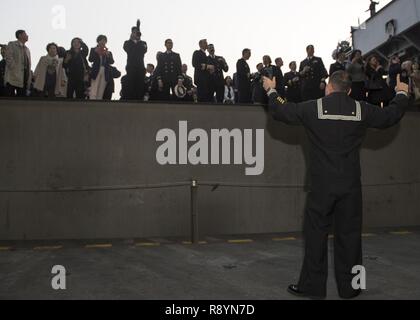 BUSAN, Repubblica di Corea (marzo, 18, 2017) di aviazione di Boatswain Mate (manipolazione) 1a classe Reynaldo Lemusmedina dirige un aeromobile ascensore che porta gli ospiti per il ponte di volo per un tour durante una repubblica di Corea la reception a bordo della portaerei USS Carl Vinson (CVN 70). La Carl Vinson Strike gruppo è su un regolarmente programmati Pacifico occidentale la distribuzione come parte degli Stati Uniti Flotta del pacifico-led iniziativa di estendere il comando e le funzioni di controllo di Stati Uniti 3a flotta. Stati Uniti Navy portaerei strike gruppi hanno pattugliato il Indo-Asia-Pacifico regolarmente e sistematicamente per più di 70 anni. Foto Stock