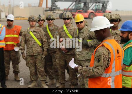 Il personale Sgt. Collin Williams (destra), le operazioni noncommissioned officer in carica per il 936th terminale Expeditionary elemento operativo e nativo di Brooklyn, N.Y., dà una breve di sicurezza prima di soldati e appaltatori di iniziare il noioso processo di scarico e di ricarico grandi e medie di velocità, roll on roll off veicolo nave cargo USNS Brittin (T-AKR-305), presso il porto di Shuaiba, Kuwait, 12 marzo. I soldati e i contraenti scaricherà circa 700 pezzi di equipaggiamento militare e ricaricare un altro di 500 pezzi. Foto Stock