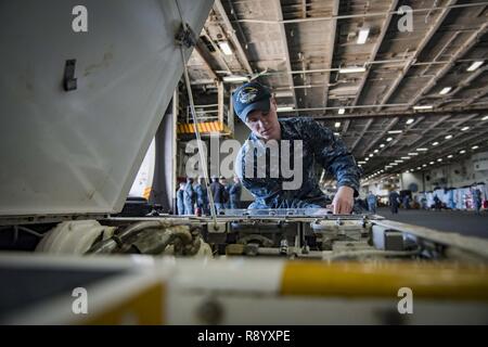 NORFOLK, Virginia (2 maggio 2017) Aviazione Equipaggiamento di supporto tecnico Airman apprendista Tanner Swartz dalla prospettiva, Penn., esegue le operazioni di manutenzione su un spotting dolly nella baia di hangar della portaerei USS Dwight D. Eisenhower CVN (69) (IKE). Ike è attualmente pier lato durante la fase di supporto della flotta ottimizzato il piano di risposta (OFRP). Foto Stock