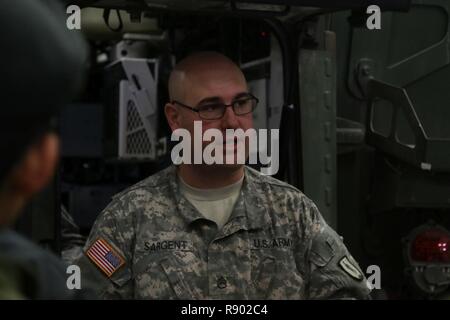 Il personale Sgt. John Sargent, un motore di trasporto istruttore operatore con 106ª regionale istituto di formazione, New York Army National Guard, descrive un veicolo Stryker per un gruppo di cadetti canadese dalla trentaduesima Polizia Militare e 709th segnali Toronto Army Cadet Corps durante la loro settimana di visita a Fort Drum. I cadetti imparato su una varietà di stati uniti Veicoli militari durante il loro tempo con Sargent. Foto Stock