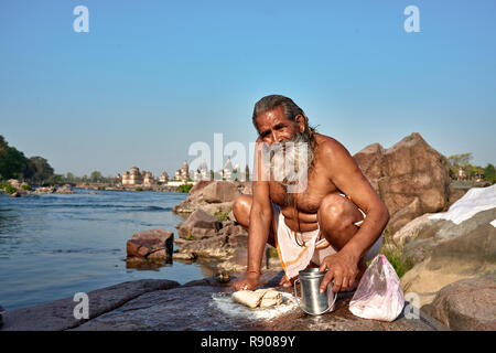 Orchha, Madhya Pradesh, India - 20 Ottobre 2018: cucina indiana. Uomo indù la preparazione di chapati nel villaggio locale. Chapati come un pasto tradizionale in India Foto Stock