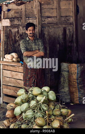 Varkala Kerala, India - 30 Novembre 2017: Ritratto di non identificato uomo indiano con coconats. Lo stile di vita quotidiano in area rurale in India del Sud. Foto Stock