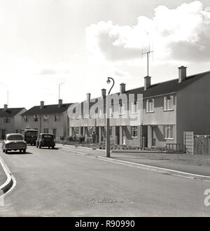Degli anni Cinquanta, storico, post-guerra in Gran Bretagna, vista esterna di una struttura di recente costruzione zona residenziale, con vetture dell'era parcheggiato in strada, Inghilterra, Regno Unito. Foto Stock