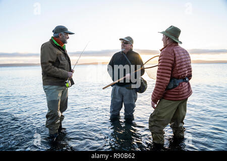 Due fly fisherman parlare all loro guida sulle nuove tecnhiques mentre la pesca a mosca per searun costiere trota spietato su una spiaggia a nord ovest coastli Foto Stock