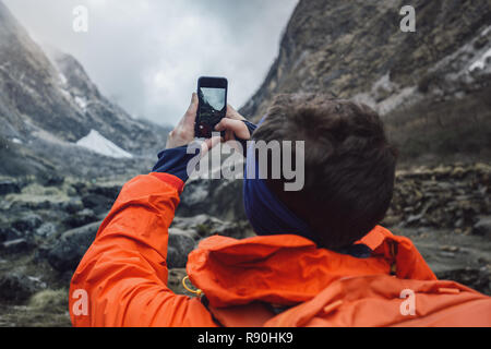 Escursionista tenendo la foto del bellissimo paesaggio di montagna Foto Stock