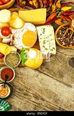 Vari tipi di formaggio servita su un tavolo di legno. Tavola di legno con diversi tipi di squisiti formaggi sulla tavola. Vendita di formaggi. Cibo sano. La proteina Foto Stock