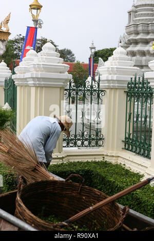 Giardiniere taglia la siepe che circonda lo Stupa della Principessa Kantha Bopha, Pagoda d'argento, Phnom Penh Cambogia Foto Stock