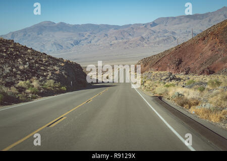 Vista dalla strada senza fine attraverso il Parco Nazionale della Valle della Morte (California State Route 190), con una vista delle montagne della Sierra Nevada in backgrou Foto Stock