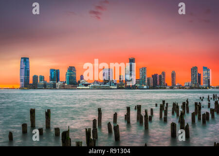 Città di Jersey, New Jersey, Stati Uniti d'America skyline attraverso il Fiume Hudson dopo il tramonto. Foto Stock