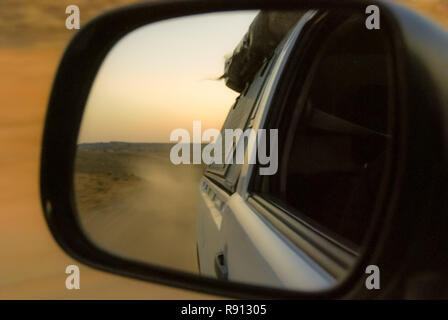 Strada di ghiaia del Deserto della Namibia si riflette in specchio retrovisore di un 4x4 off road pick up veicolo Foto Stock