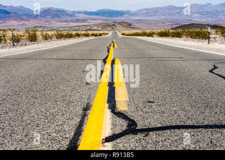 Angolo basso a metà strada vista attraverso il Parco Nazionale della Valle della Morte (California State Route 190), con una vista delle montagne della Sierra Nevada in b Foto Stock