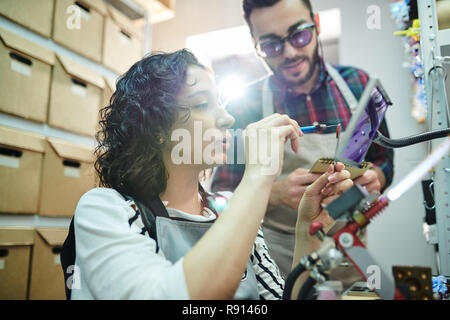 Due artigiani in negozio per lavorazione vetro Foto Stock
