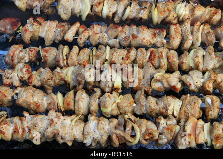 Stuzzicanti spiedini closeup. Cuocere la carne di maiale. Pranzo a barbecue all'aperto. Cubi di grigliate di carne di maiale. Spiedini preparati sul barbecue grill a carbone Foto Stock