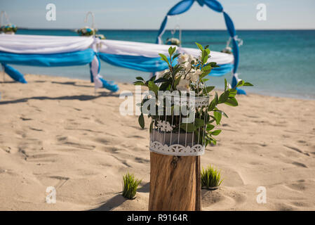 Il setup di giorno di nozze matrimonio corsia con tendaggi e arco sulla sabbiosa spiaggia tropicale paradiso per aprire Sfondo oceano Foto Stock