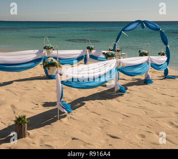 Il setup di giorno di nozze matrimonio corsia con tendaggi e arco sulla sabbiosa spiaggia tropicale paradiso per aprire Sfondo oceano Foto Stock