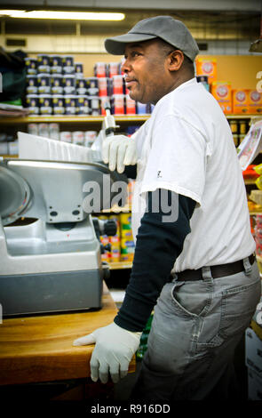 L'affettatrice di bacon Frank Moore guarda i clienti archiviare i file nel Williams Brothers General Store, 11 dicembre 2011, a Philadelphia, Mississippi. Foto Stock