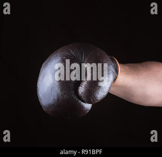 Marrone guanto boxe vestito su mano d'uomo, sfondo nero Foto Stock