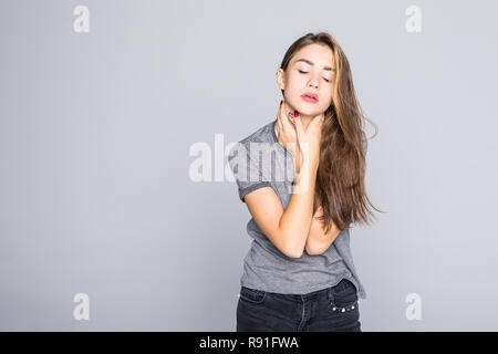 Indietro e la spina dorsale della malattia. Closeup ritratto stanco donna massaggiare la sua dolorosa collo isolato sul muro grigio Sfondo. Foto Stock