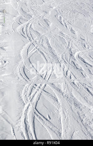 Snowy piste da sci con tracciato da sci e snowboard in inverno pieno di sole giorno Foto Stock