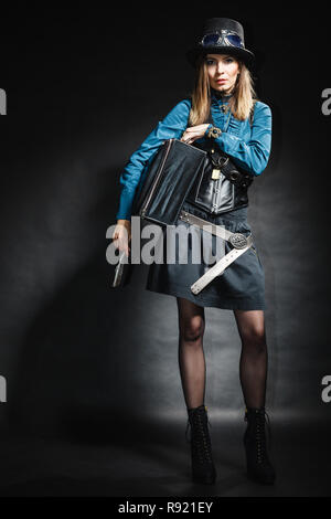 A piena lunghezza steampunk retrò donna con borsa valigia studio shot grunge sfondo scuro Foto Stock