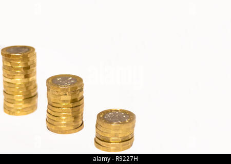 Pile e cumuli di British GBP monete doro Moneta soldi su sfondo bianco con spazio vuoto Foto Stock