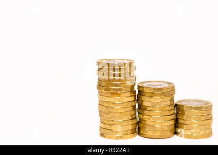 Pile e cumuli di British GBP monete doro Moneta soldi su sfondo bianco con spazio vuoto Foto Stock