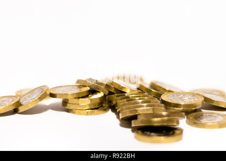 Pile e cumuli di British GBP monete doro Moneta soldi su sfondo bianco con spazio vuoto Foto Stock