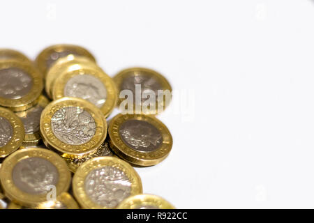 Pile e cumuli di British GBP monete doro Moneta soldi su sfondo bianco con spazio vuoto Foto Stock