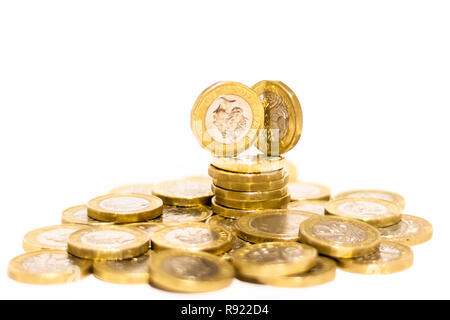 Pile e cumuli di British GBP monete doro Moneta soldi su sfondo bianco con spazio vuoto Foto Stock