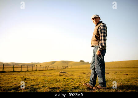 Ritratto di un contenuto coppia agricoltore a piedi attraverso un campo sulla sua azienda. Foto Stock