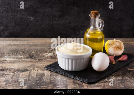 Salsa Aioli e gli ingredienti sul tavolo di legno. Copyspace Foto Stock