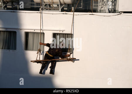 L'uomo pittura barca porto di Lavrion lavrio attica grecia Foto Stock