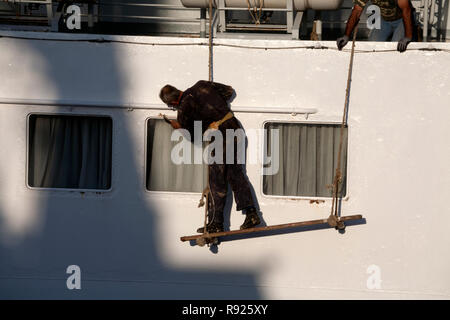 L'uomo pittura barca porto di Lavrion lavrio attica grecia Foto Stock