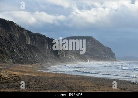 Charmouth, Dorset, Regno Unito. 19 dicembre 2018. Regno Unito Meteo. Una vista delle scogliere di frantumazione che conduce al Golden Cap a distanza con un moody cielo sopra come si vede dalla spiaggia Charmouth sul Dorset Jurassic Coast su una mattina di sunny incantesimi. Credito Foto: Graham Hunt/Alamy Live News Foto Stock