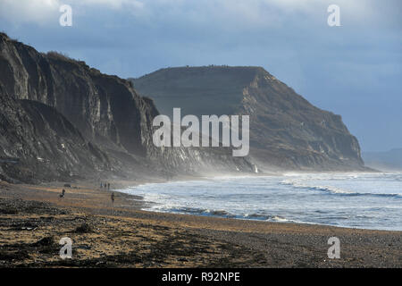 Charmouth, Dorset, Regno Unito. 19 dicembre 2018. Regno Unito Meteo. Una vista delle scogliere di Golden Cap con un moody cielo sopra come si vede dalla spiaggia Charmouth sul Dorset Jurassic Coast su una mattina di sunny incantesimi. Credito Foto: Graham Hunt/Alamy Live News Foto Stock