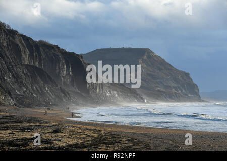 Charmouth, Dorset, Regno Unito. 19 dicembre 2018. Regno Unito Meteo. Una vista delle scogliere di Golden Cap con un moody cielo sopra come si vede dalla spiaggia Charmouth sul Dorset Jurassic Coast su una mattina di sunny incantesimi. Credito Foto: Graham Hunt/Alamy Live News Foto Stock