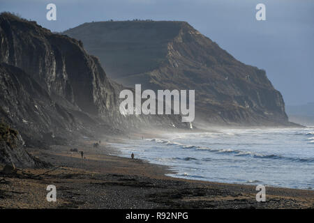 Charmouth, Dorset, Regno Unito. 19 dicembre 2018. Regno Unito Meteo. Una vista delle scogliere di Golden Cap con un moody cielo sopra come si vede dalla spiaggia Charmouth sul Dorset Jurassic Coast su una mattina di sunny incantesimi. Credito Foto: Graham Hunt/Alamy Live News Foto Stock