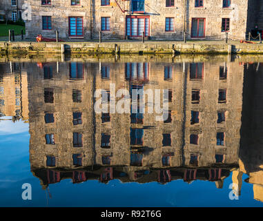 Leith, Edimburgo, Scozia, Regno Unito. Xix Dec, 2018. Regno Unito Meteo: una bella giornata di sole nella capitale con la mancanza di vento creando riflessi nell'acqua del fiume di Leith. Riflessioni di un convertito deposito obbligazionario denominato Barileria shining in acqua Foto Stock