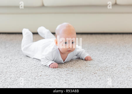 Famiglia, concetto di infanzia - Close up ritratto di pretty baby giacciono sul pavimento Foto Stock