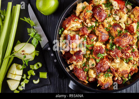 Versione classica del Ringraziamento o di natale ripieno, fatta con pane, sedano, cipolla, mele, castagne, timo e salvia in una casseruola di nero con in Foto Stock