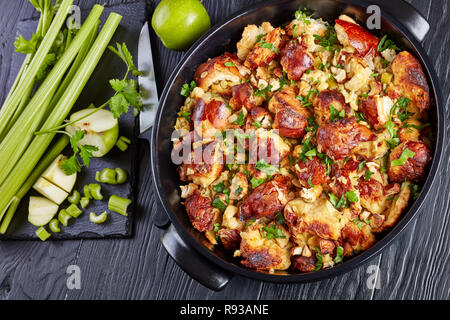 Versione classica del Ringraziamento o di natale ripieno con croccante, rosolato top, fatta con pane, sedano, cipolla, mele, castagne e le erbe in un nero Foto Stock