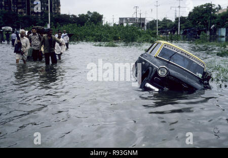 Taxi sommerso dalle inondazioni di acqua piovana per strada nella stagione dei monsoni Bombay Mumbai Maharashtra India monsone indiano Asia Asia Asiatica Foto Stock