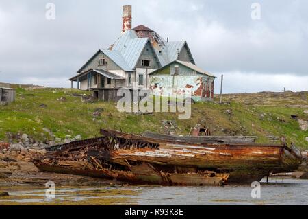 Abbandonate le piccole barche da pesca, MRB, di fronte a una casa abbandonata in una località rurale sul Mare di Barents, Dalniye Zelentsy Foto Stock