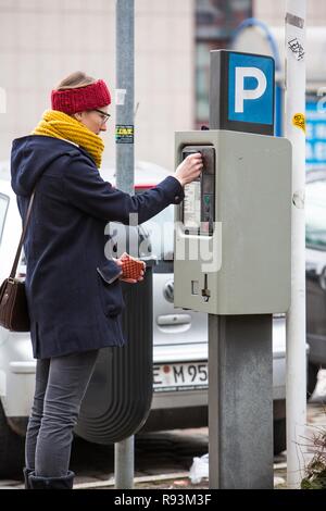 La donna acquista un biglietto di parcheggio da un parcheggio ticket distributore, all interno della città. Parcheggio pubblico, Essen Foto Stock