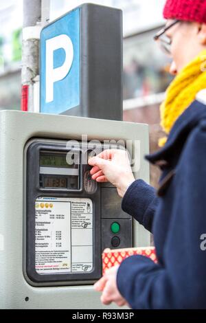 La donna acquista un biglietto di parcheggio da un parcheggio ticket distributore, all interno della città. Parcheggio pubblico, Essen Foto Stock